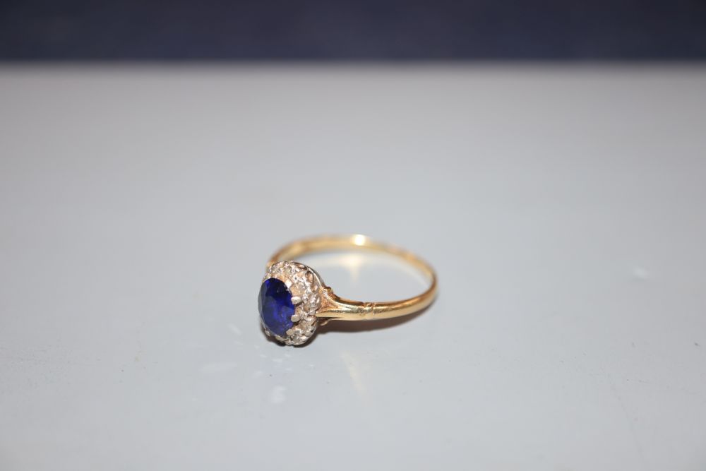 An 18ct, sapphire and diamond set oval cluster ring, size T, gross 3.2 grams.